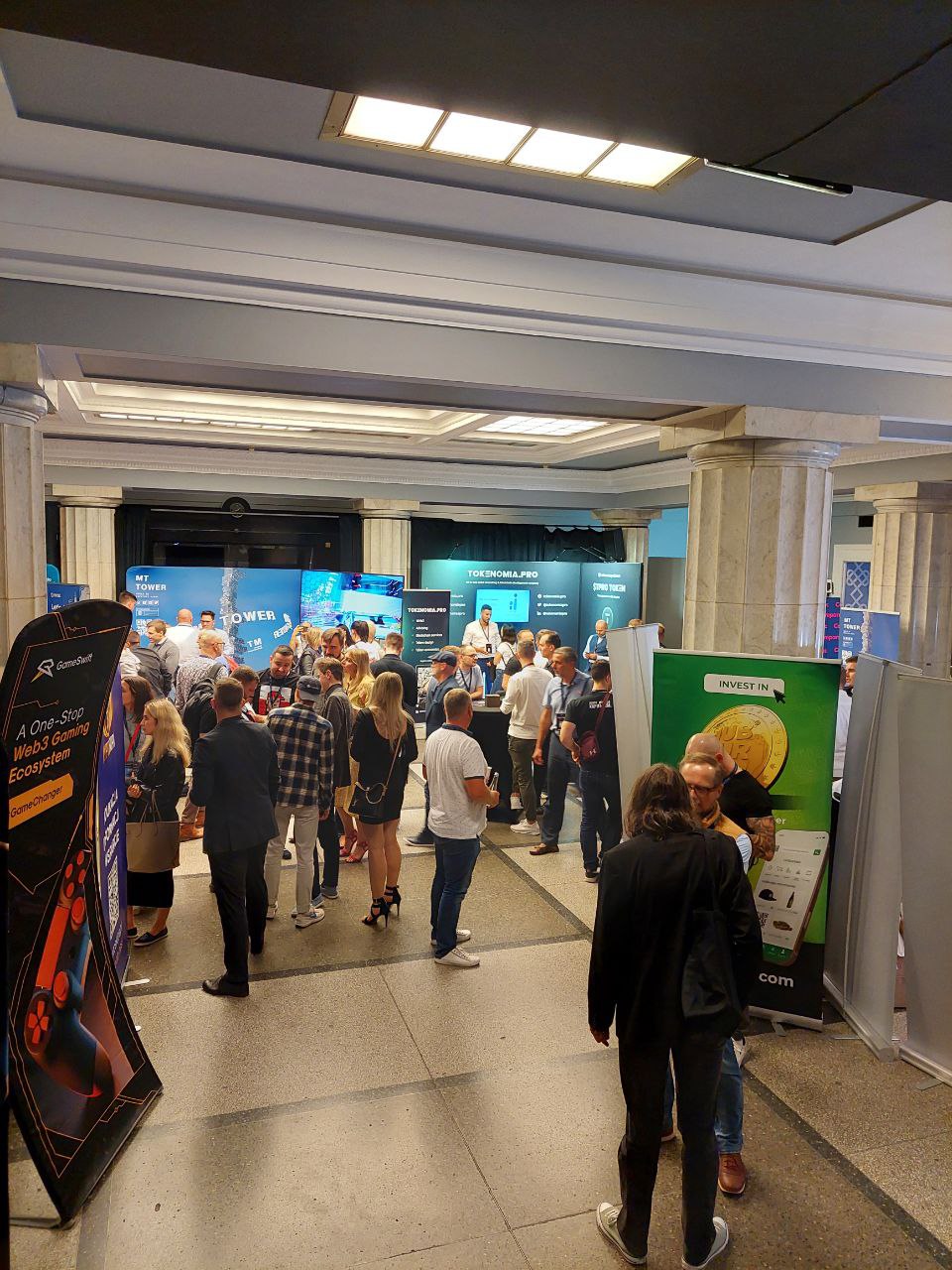 CryptoVerse Expo floor with exhibition booths and attendees